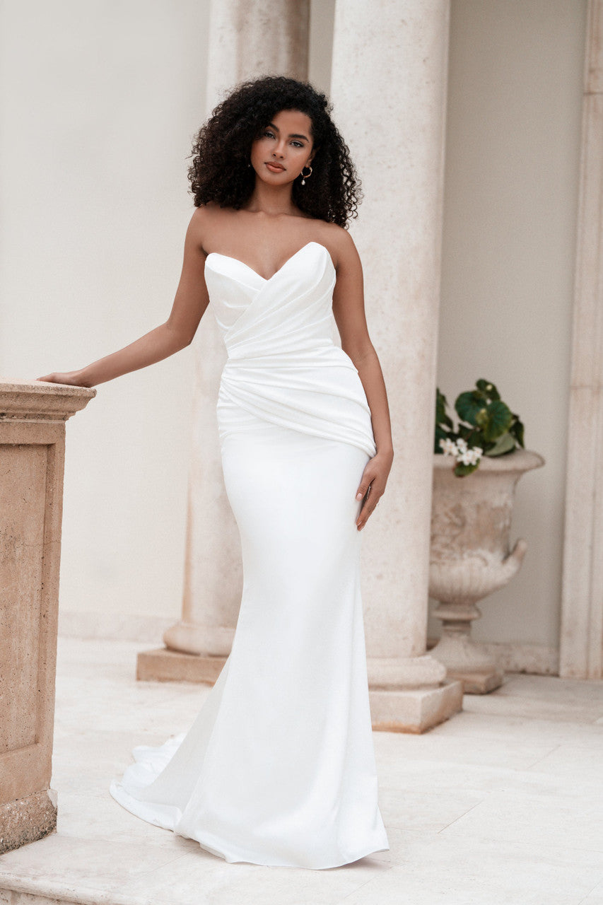 Stretch satin sheath features a pointed sweetheart neckline and a ruched bodice .