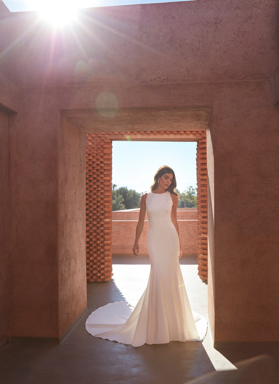 Madison James-Blends modern minimalism with intricate detailing, featuring a high boat neckline