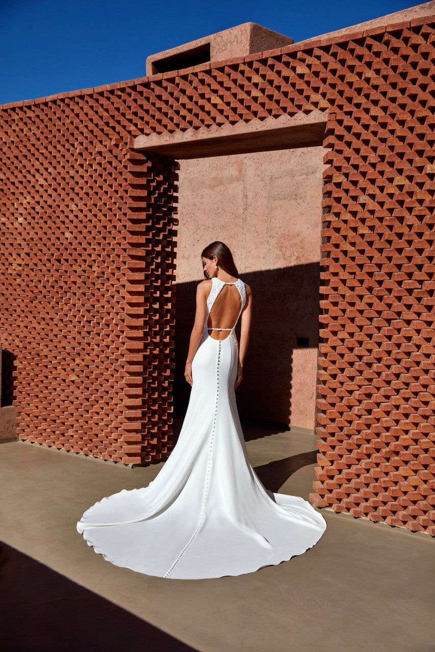 Madison James-Blends modern minimalism with intricate detailing, featuring a high boat neckline