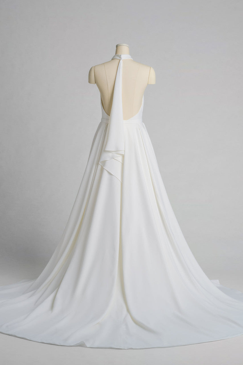 Victoria is a high-neck halter gown in liquid satin that drapes with quiet luxury.